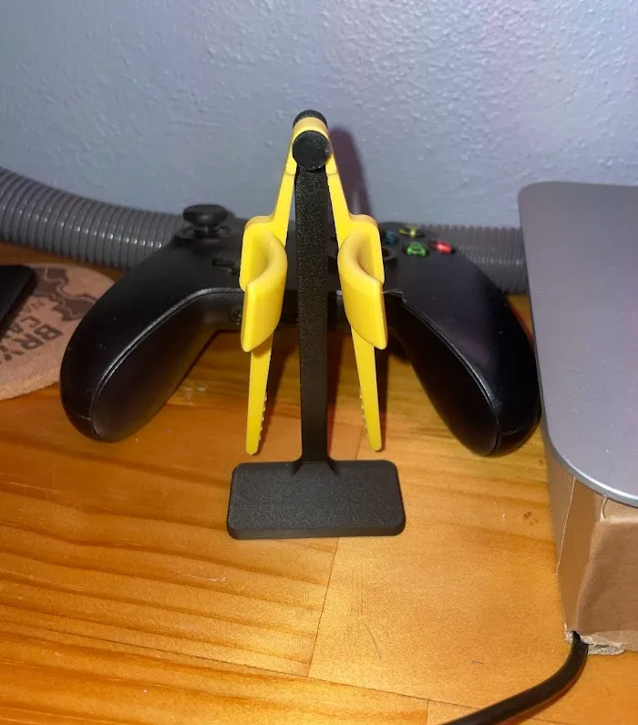 3D-printed finger-chopstick stand between two Xbox controllers
