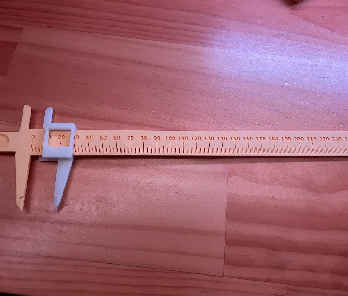 3D-printed caliper measured against a ruler for accuracy