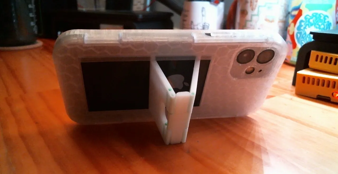 Folding phone kickstand case propped on a desk, rear three-quarter view